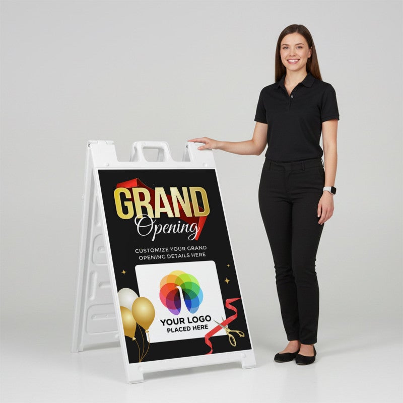 A woman standing next to the grand opening A-frame sign with her hand on the top of the sign