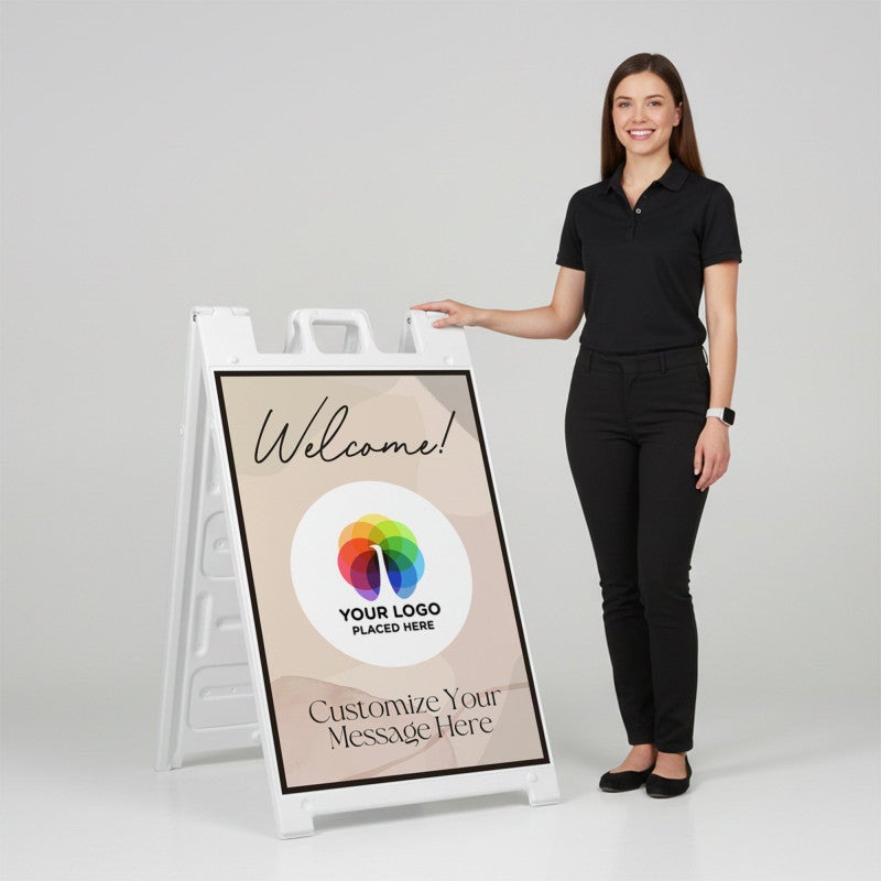 A woman standing next to a Welcome A-frame sign with her hand on the top of the sign