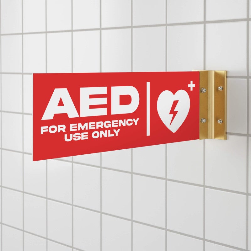 The red projecting AED sign in a bathroom