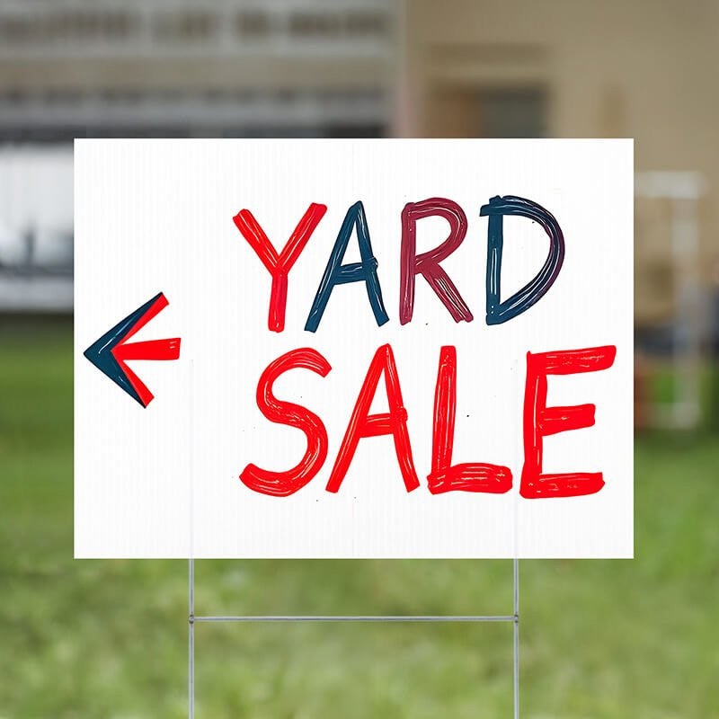 A custom made yard sign written in marker for a yard sale