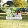 Gold text graduation yard sign displayed on a sunny yard