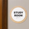 A 2-layer round ADA sign for a study room next to a doorframe