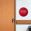 A 2-layer round ADA sign for a storage closet next to a doorway