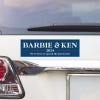 Barbie and Ken bumper sticker above a white car's tail light
