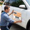 A man appling a car magnet to an SUV