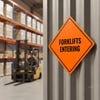 An orange diamond aluminum sign displayed in a warehouse where forklifts are being operated