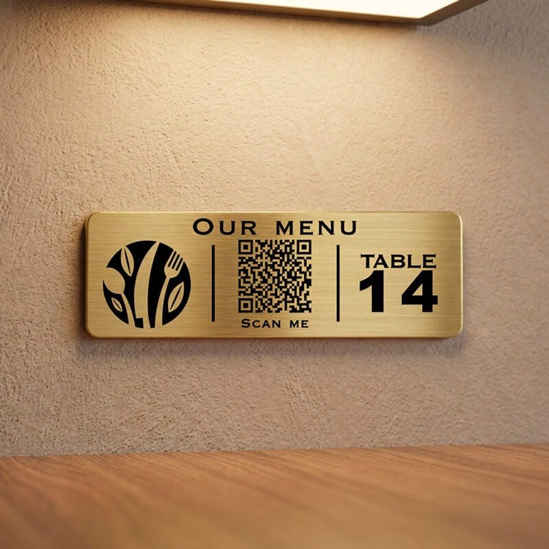 A small gold engraved plastic sign with a QR code for a restaurant menu