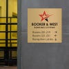 12x12 printed brass sign displayed by a doorway