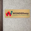 6x18 printed brass sign displayed by a doorway
