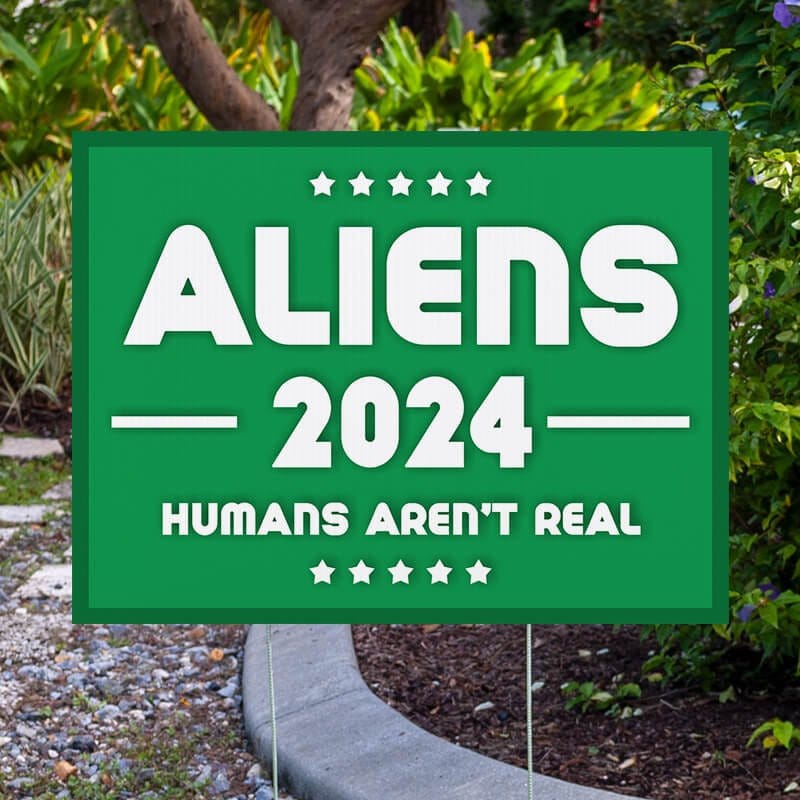 Aliens - Human Aren't Real Yard Sign Next to Pavement