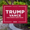 Trump Vance Red Yard Sign next to pavement