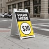 A $30 park here sandwich board sign displayed by a parking garage