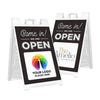 Two examples of the We Are Open sandwich board sign with an uploaded logo