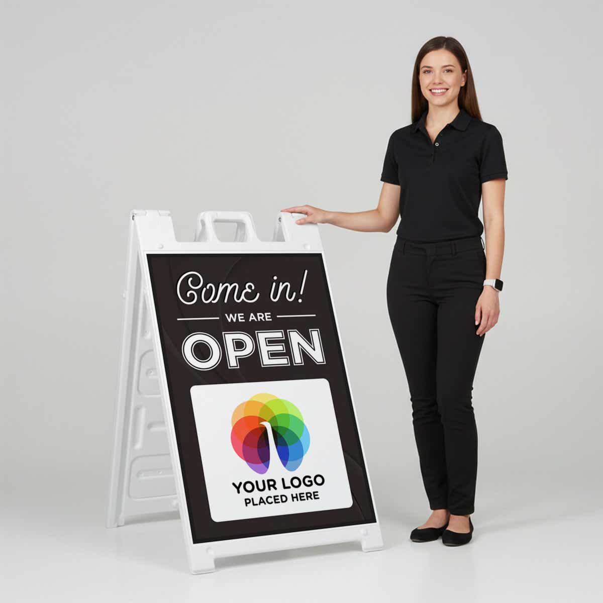 A woman standing next to an A-frame sign with her hand on the top of the sign