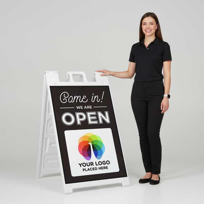 A woman standing next to an A-frame sign with her hand on the top of the sign
