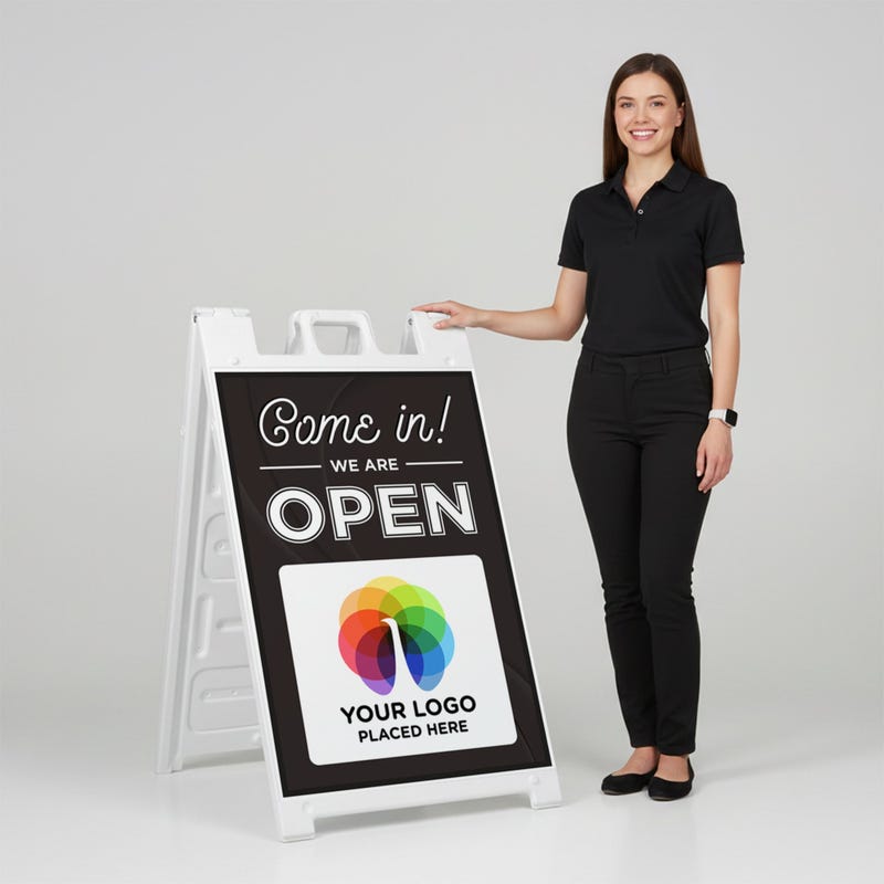 A woman standing next to an A-frame sign with her hand on the top of the sign