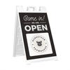 A sandwich board sign for a farmhouse that says We Are Open and features their logo