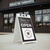 A sandwich board sign that says We Are Open and features the restaurant's logo