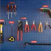 Engraved plastic labels next to tools on a blue wall