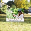 Gold text graduation yard sign displayed on a sunny yard