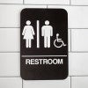 Brown Unisex Handicap Sign Hanging on a Wall