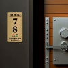 6x3 printed brass sign displayed next to a doorway