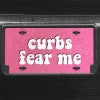 A close up of the Curbs Fear Me front license plate on a black car