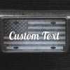 A close up of the Custom American Flag front license plate on a black car