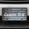 A close up of the Custom American Flag front license plate on a white car