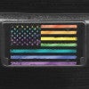 A close up of the LGBTQ Pride American Flag front license plate on a black car