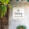 No soliciting sign, with a floral design on a white background, hung up on a wall saying family and friends are welcome
