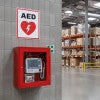 An AED sign placed above the AED in a warehouse