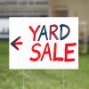 A custom made yard sign written in marker for a yard sale