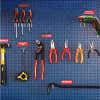 Engraved plastic labels next to tools on a blue wall