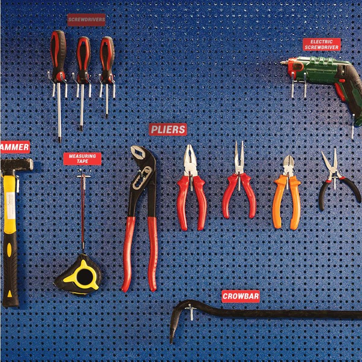Engraved plastic labels next to tools on a blue wall