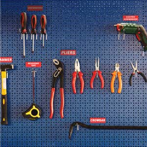 Engraved plastic labels next to tools on a blue wall