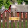 2 By 8 Brass Plate On A Picket Fence In Front Of A Barn Saying Twin Oaks, Established 2018