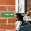 A Green Plastic Sign With a Company Logo and Says STAFF LOUNGE