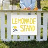 A custom made yard sign for a lemonade stand written with yellow marker