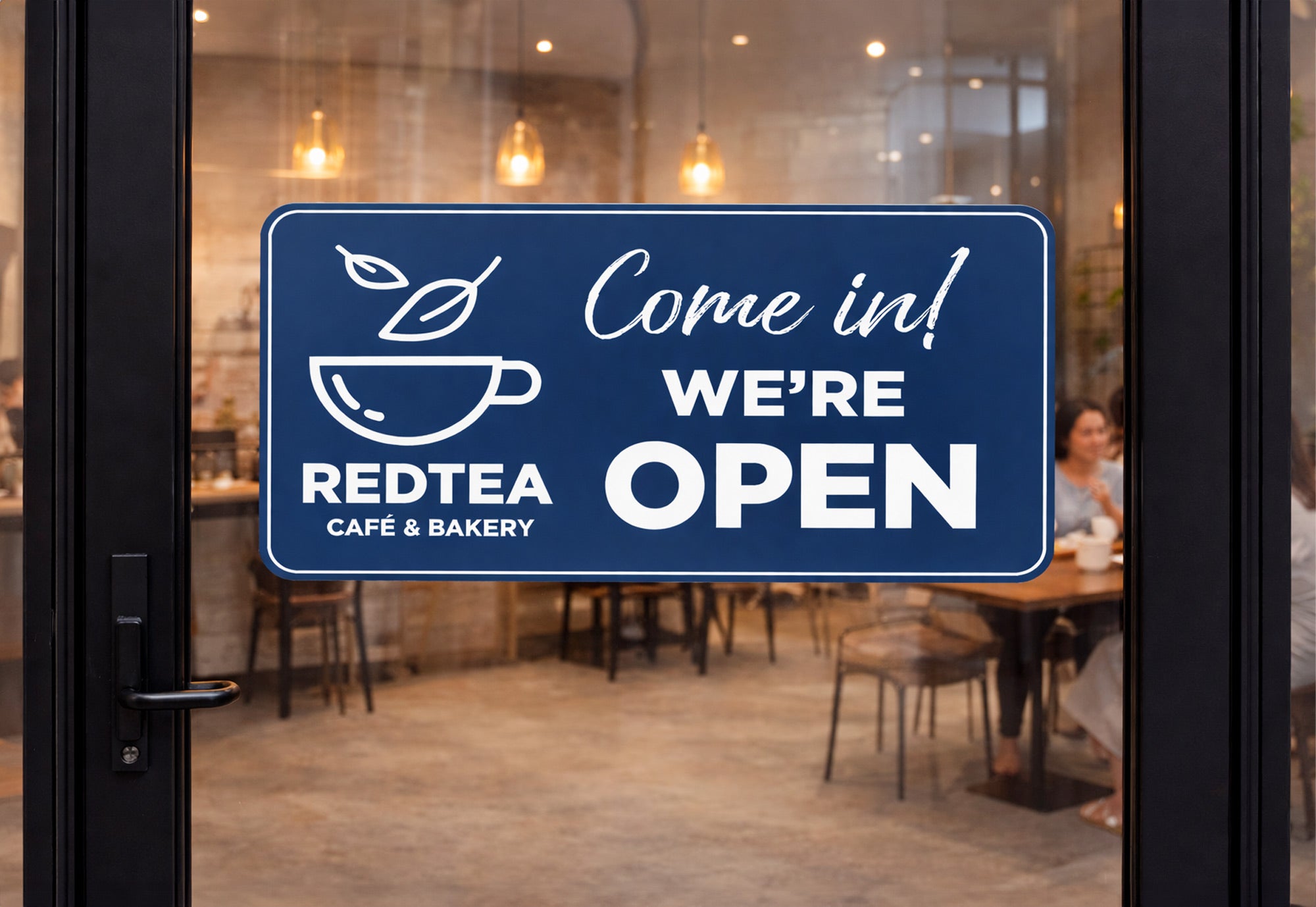 A blue engraved plastic sign for a tea shop showing that they are open